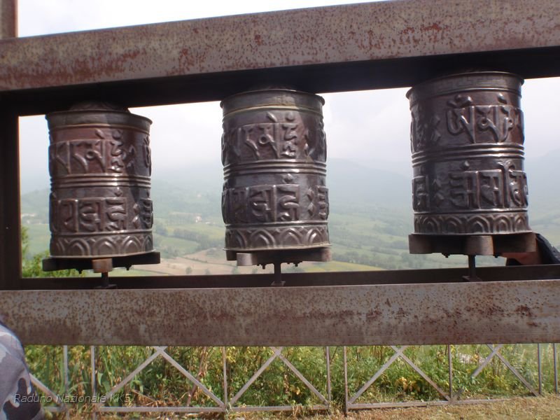 846.JPG - Attualmente la campana originale si trova in un magazzino del Jokhang, il principale tempio buddista di Lhasa, ed è l'unico reperto rimasto in Tibet a testimonianza della missione cristiana del '700. Sul monumento accanto alla Campana, come segno di incontro fra le religioni per la pace e l'armonia tra gli uomini, sono stati posti tre manikorlo o mulini di preghiera tibetani, sui quali è inciso il mantra buddista Om mani padme hum....